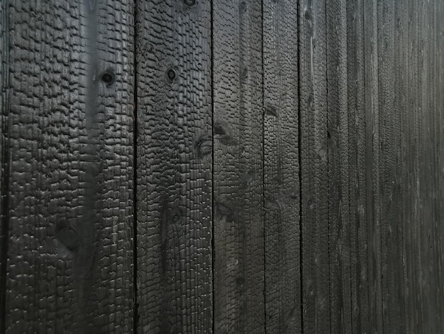 Background of beautiful pattern design with small shallow holes on the black wooden wall