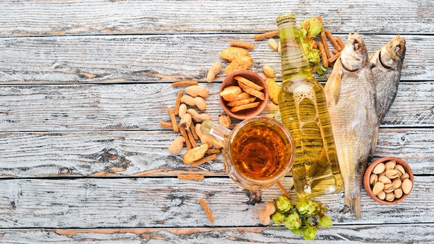 Sfondo di birra e snack luppoli patatine di birra noci su uno sfondo di legno bianco spazio libero per il testo vista dall'alto