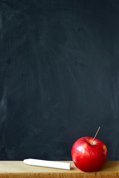 Background black chalkboard in chalk stains chalkboard and red apple, copyspace