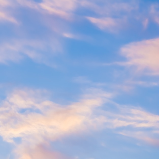 Background of blue sky with white pink clouds in sunset