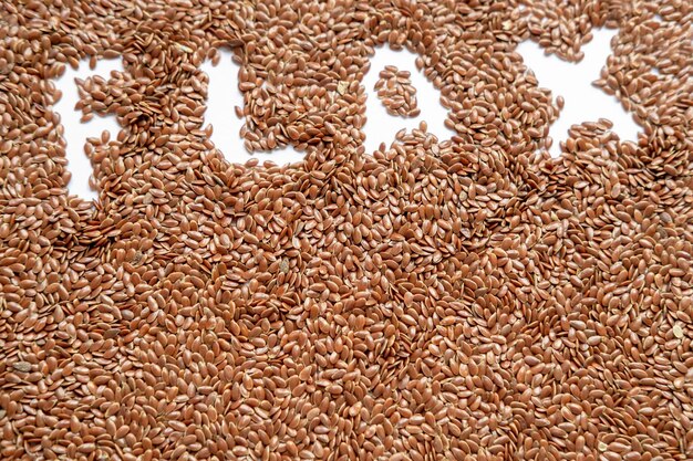 Background of brown raw dry flax seeds and Flax inscription healthy food