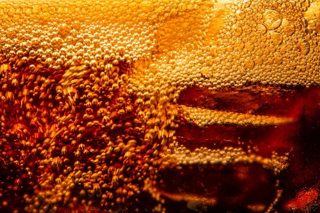 Background of cola with ice and bubbles Side view background of refreshing cola flavored soda with