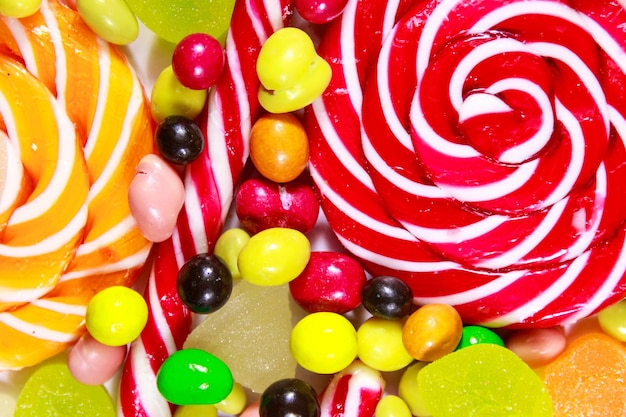 Background of colorful chocolate candies lollipops candy cane and jelly sweets