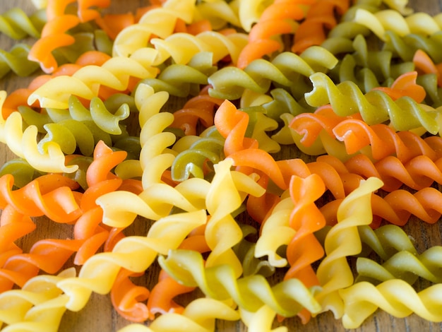 Background of colorful pasta texture close-up. close up of a dried italian pasta on a wood