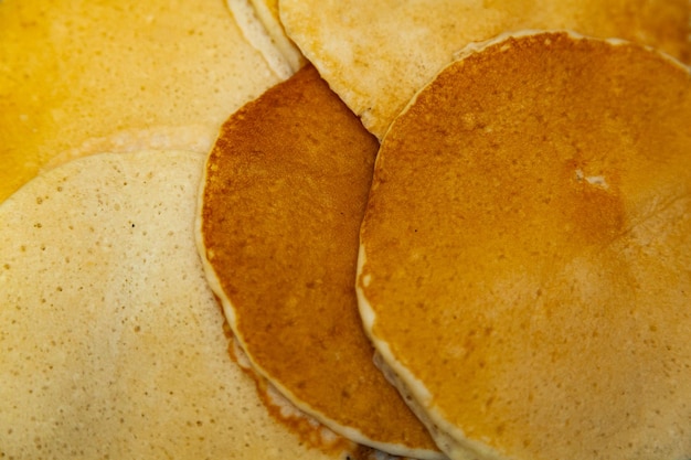 Background of cooked fried pancakes stacked randomly closeup