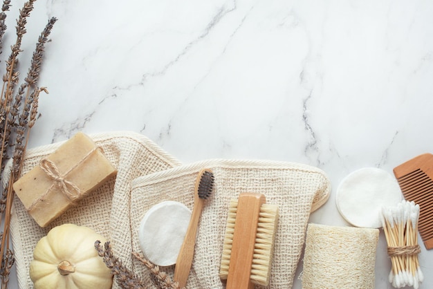 Background for cosmetics natural eco cosmetics on a gray
background a wooden brush with a cotton towel and natural soap