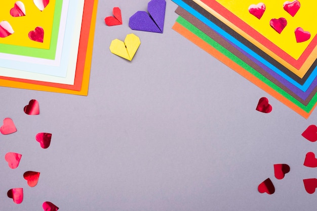 Background for creativity. Colored paper and paper hearts. Cut out of paper.