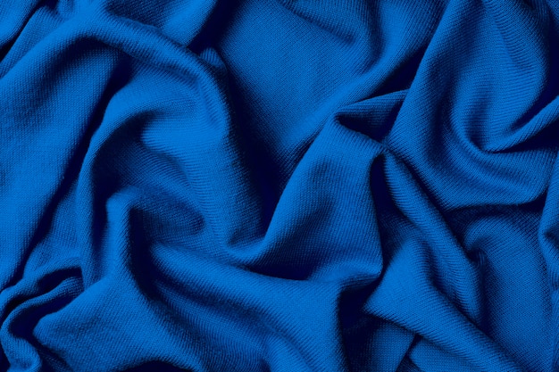 Photo background of crumpled blue cotton fabric, trend color of year 2020 classic blue.