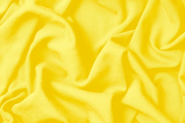 Background of crumpled yellow cotton fabric, a trend color of year 2021.