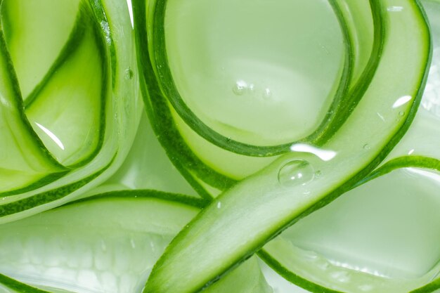 A background of cucumber slices in water Lots of cucumber slices swirled in water