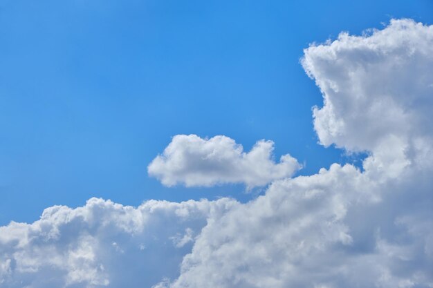 Background cumulus clouds against a blue sky illuminated by sunlight