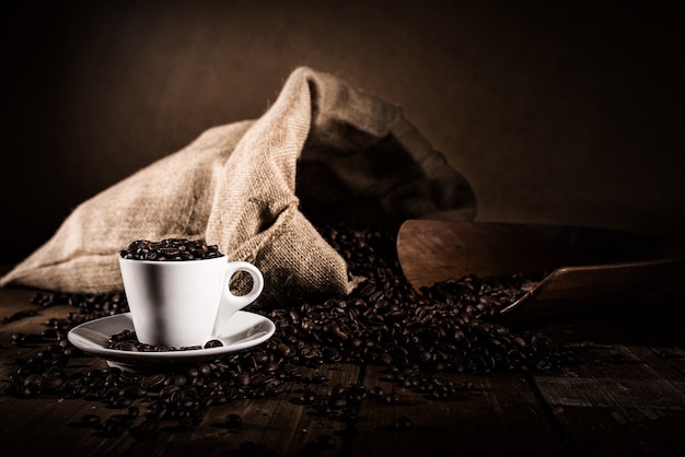 Background of cup of coffee beans with jute bag and bailer