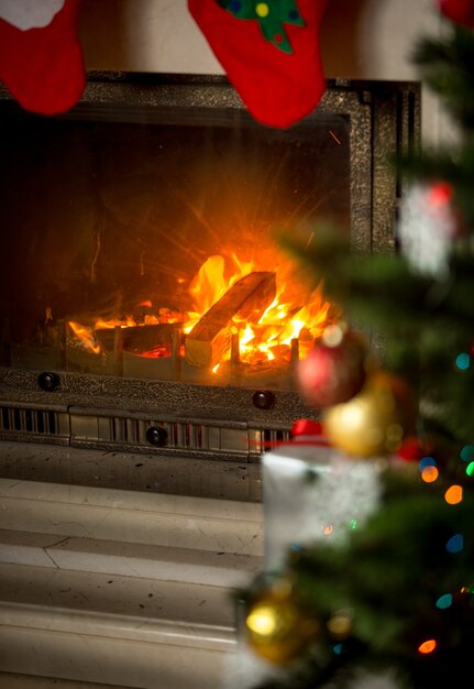 Background of decorated Christmas tree in front of burning fireplace at house