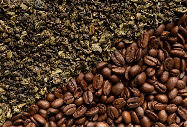 Background of dry green tea leaves and roasted coffee beans closeup with space for text