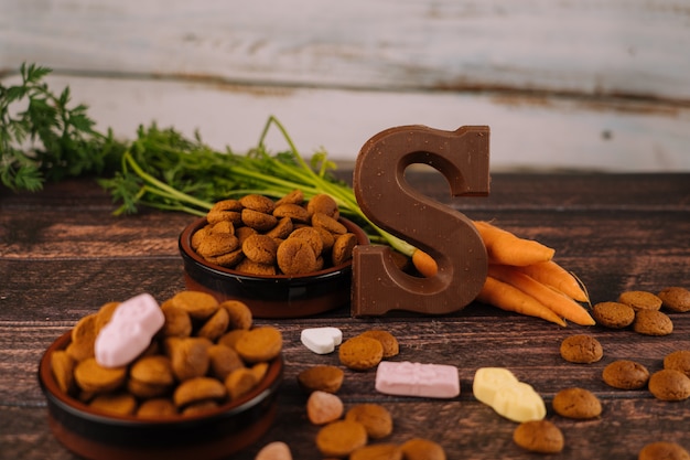 Background Dutch holiday Sinterklaaspepernoten, chocolate letter, sweets strooigoed and carrots for horse