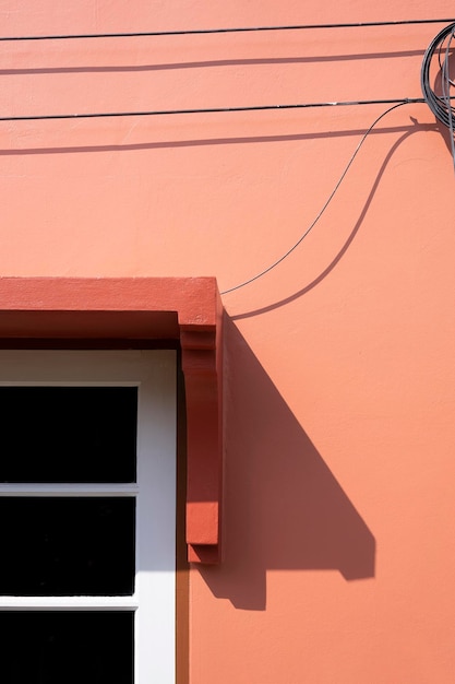 Background of electrical and internet cable lines neatly mounted on exterior wall of brown house