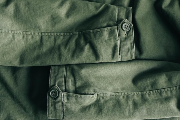 Background of folding sleeves of green jacket and buttons with seam line Clothing detail