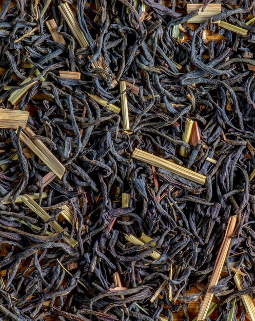 Photo background of fragrant black tea leaves with lemon grass dry texture of black tea