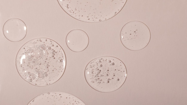 Фото Фон из косметических гелевых капель с пузырьками. вид сверху, антибактериальная жидкая поверхность. хорошо подходит в качестве фона или макета, большого баннера.