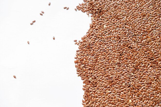 Background from flax seeds on the right on white background on the left with copy space