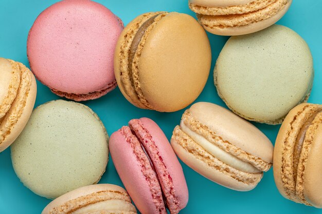 Background from multicolored macaroons on a bright blue background top view