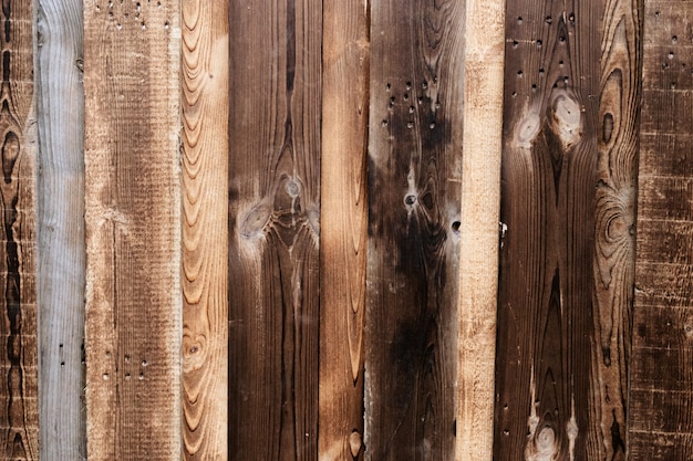 Background from old pieces of wood. Natural wood texture. Old fence. Brown old wooden fence.  Dark wood.