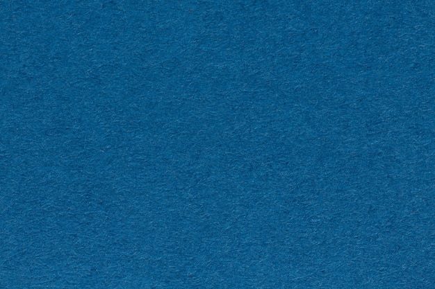 Background from sheet of dark blue color paper close up. High resolution photo.