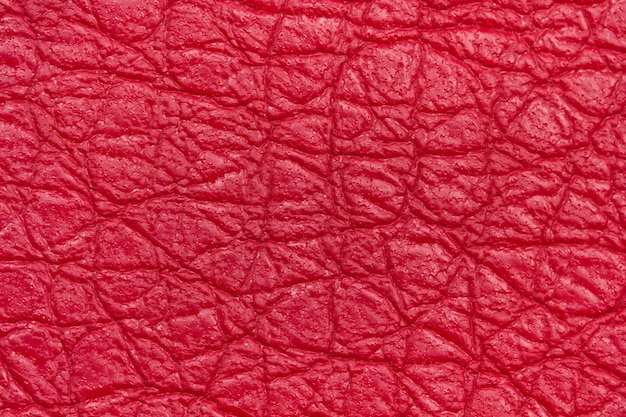 Photo background from the structure of the factory leather in red in crumpled style in macro