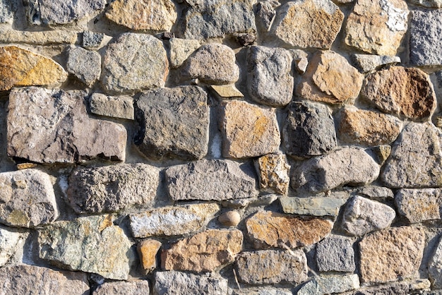 Background from a wall with stones in sunlight