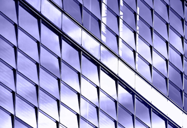 Background of glass windows of modern business office building, diagonal perspective, toned in lavender, very peri, color of year 2022