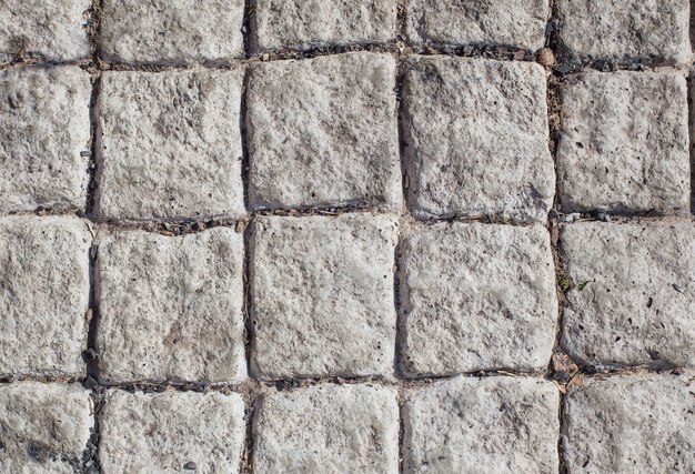 Background of gray stone paving slabs in sunlight