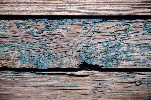 A background of green peeling paint on an old wooden wall Uneven texture of the boards