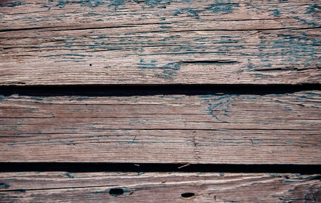 A background of green peeling paint on an old wooden wall Uneven texture of the boards