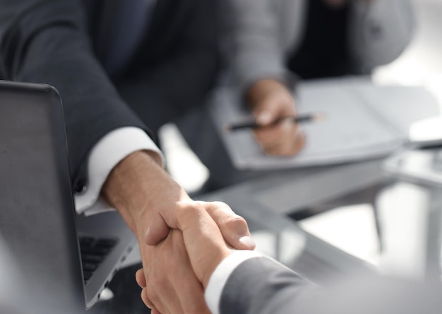 Background image of business handshake over the desk