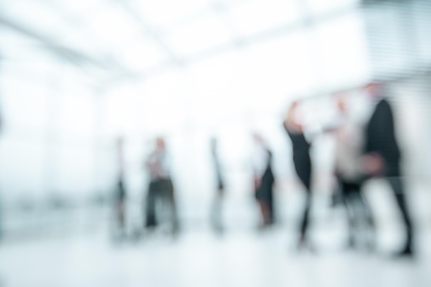 Background image of a group of business people standing in the office lobby.