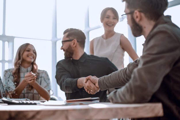 Background image of the handshake of business partners in the office