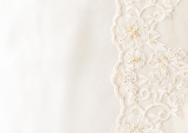 Background image of ivorycolored satin fabric and lace with a bisser on one side border wedding background with a copy of the space