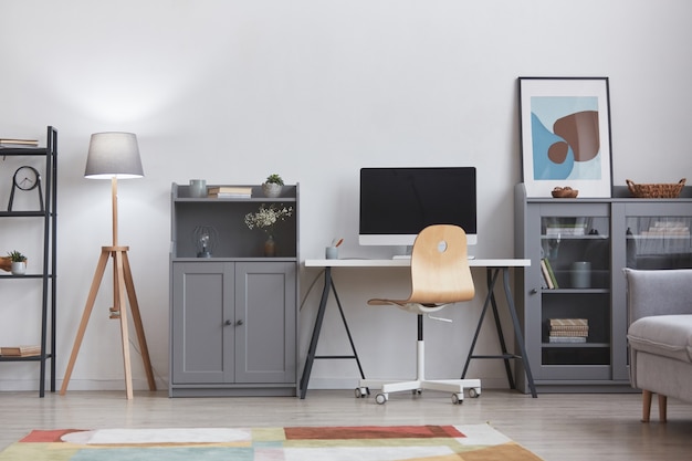 Background image of minimal interior with focus on modern home workplacein grey and white tones, copy space