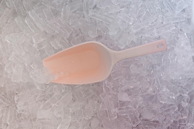 Immagine di sfondo con ghiaccio fresco rinfrescante e cucchiaio.