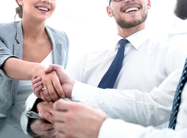 Background imagehandshakes colleagues at the Desk