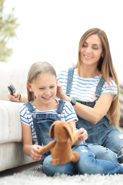 Background imageMother with a little daughter sitting on the couch at home