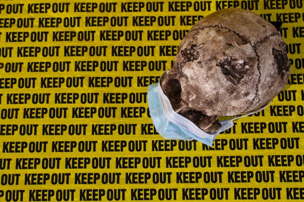 Background keep out distance warning sign with human skull in medical mask