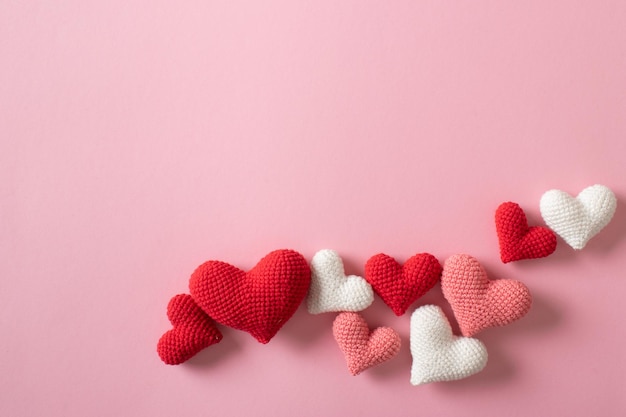 Background of knitted hearts on a light pink background for Valentine's Day