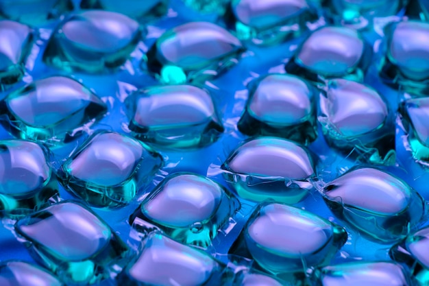 Background lot of capsules for washing green on blue background