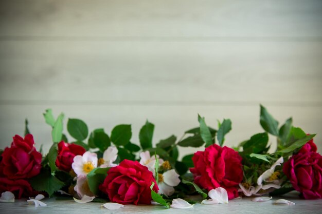 Background of many red roses on a light wooden