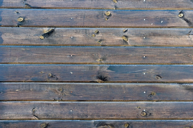 Background of natural knotted brown wood fence.