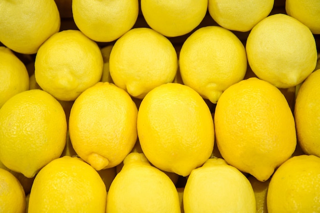 Фото Фон из многих желтых лимонов на прилавке на рынке или в магазине