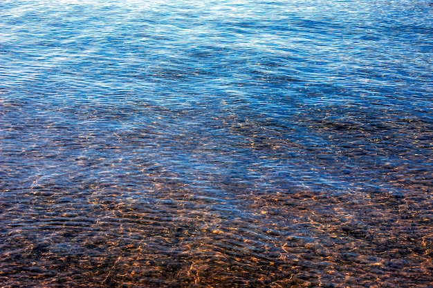 Фото Фон воды озера траунзее в прибрежной зоне цветная текстура камней под водой