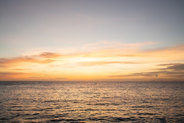 海に向かってオレンジ色の夕暮れの夕焼け空の背景