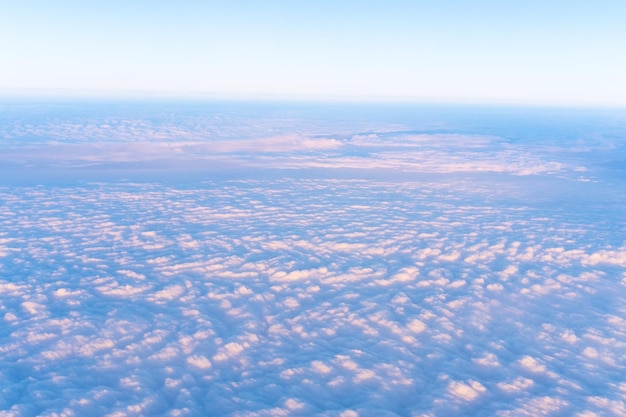 Background of a pink heavenly sky with fluffy dense clouds top view from an airplane Can be used as advertising background